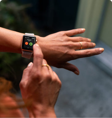  A woman with rings on uses her smart watch to lock her front door remotely