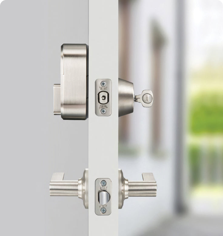 The side view of a silver august lock on a door with a key in the lock