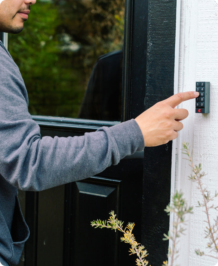 A man using the keypad outside his front door