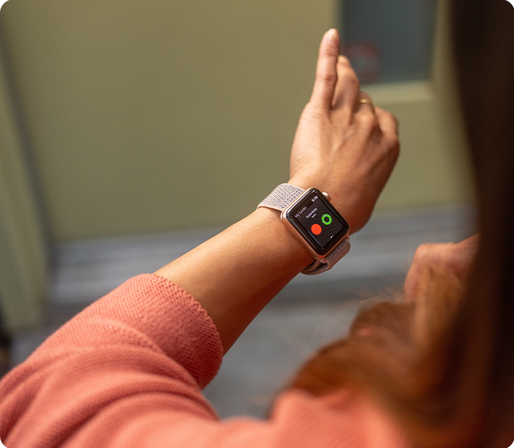 A woman checks the status of her wifi smart lock on her smartwatch