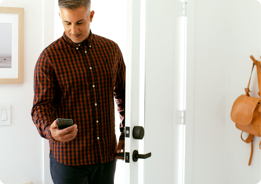 Man unlocking his door with the August app